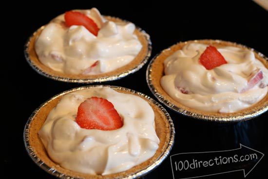 fill pie crusts with yogurt, COOL WHIP mix and top with strawberry slice
