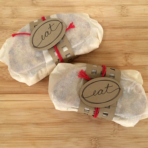 Sandwiches wrapped with parchment paper and a picnic wrapper designed by Jen Goode