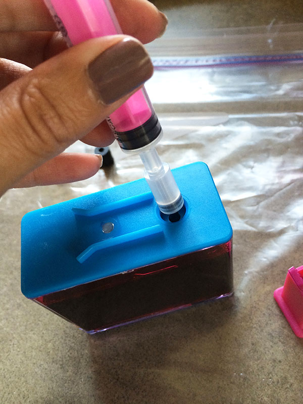 Use syringe to extract ink from ink container