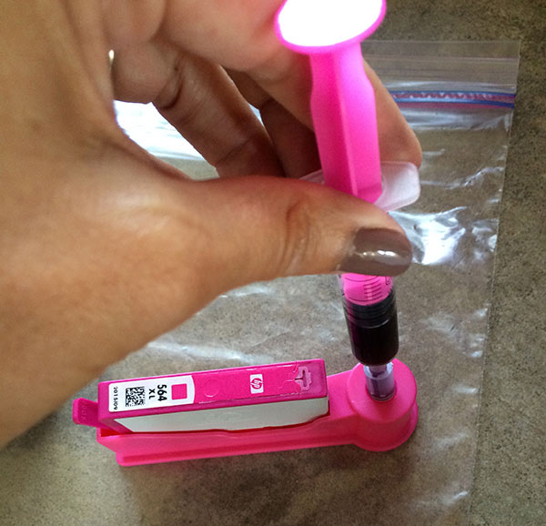 Add ink to the cartridge by pressing syringe down on cartridge holder