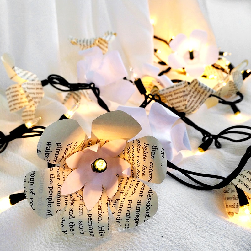 Pretty paper flowers decorate a string of lights
