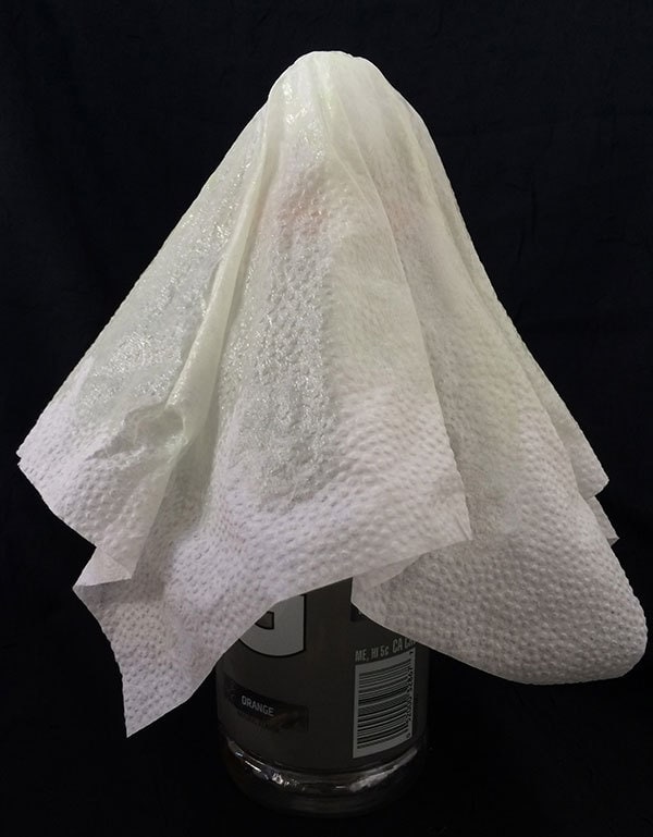 Drape napkin on plastic bottle form and allow to dry