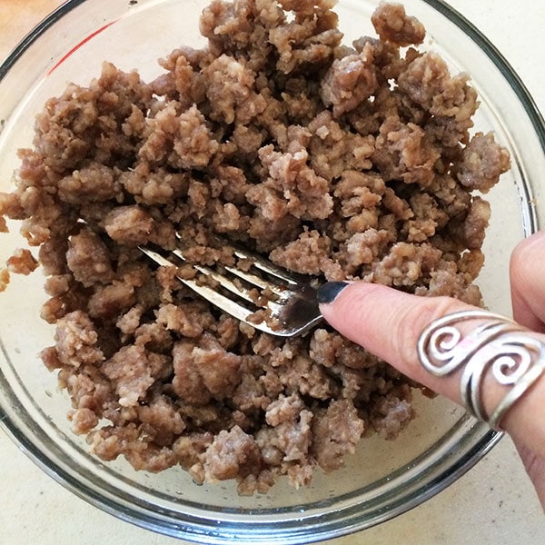 Use fork to break sausage into smaller pieces