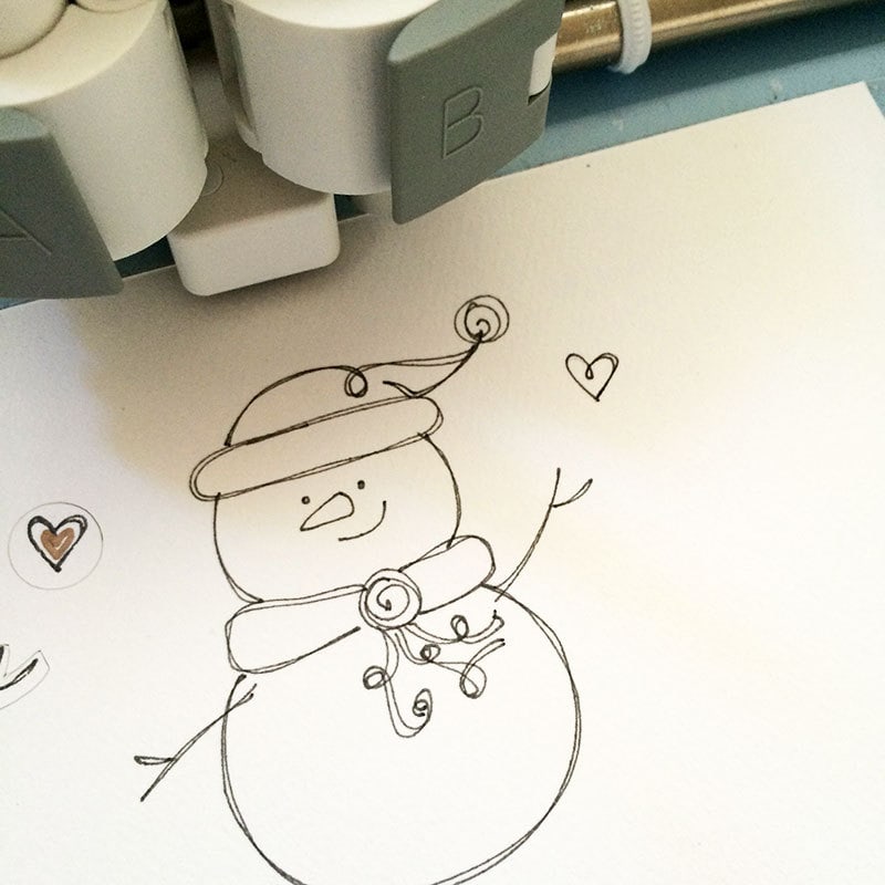 The Cricut Explore will draw the snowman art and accents
