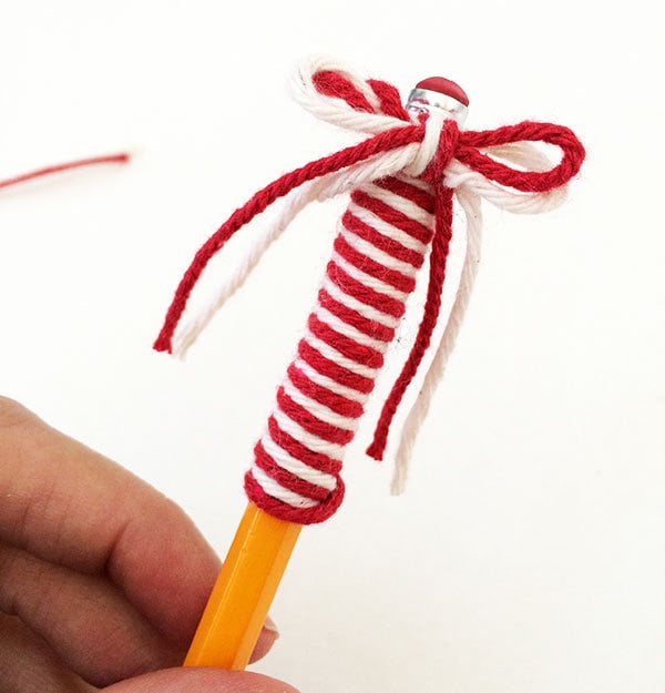 Tie a yarn bow at eraser of pencil
