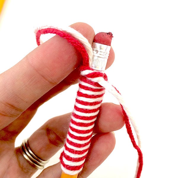 Wrap pencil with yarn and tie off at eraser