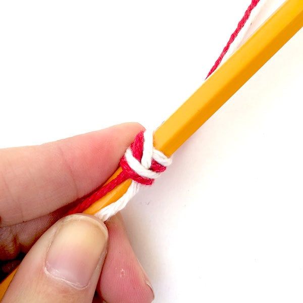 Pull up tail toward eraser and wrap yarn over it