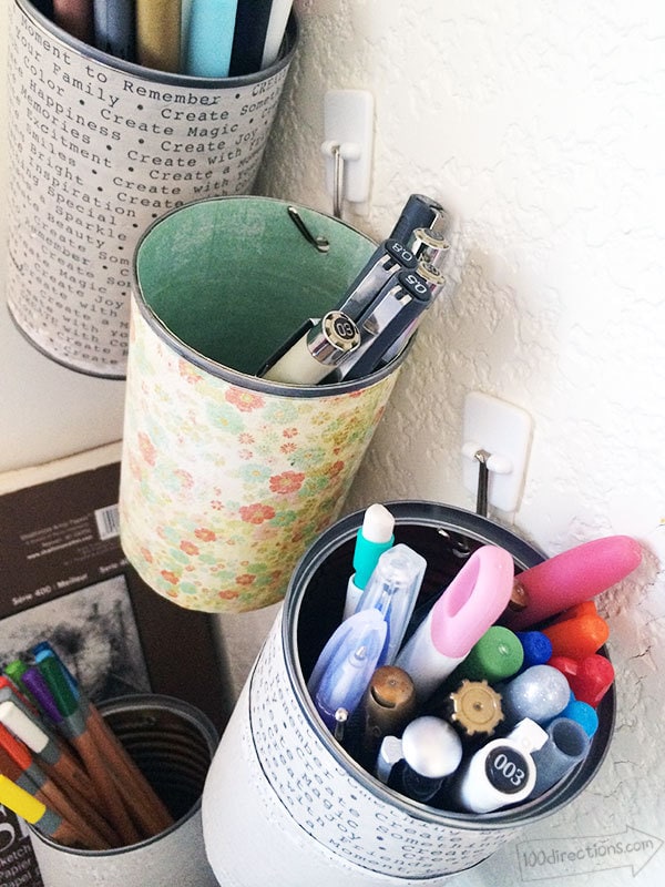 Organize pens and pencils in hanging cans