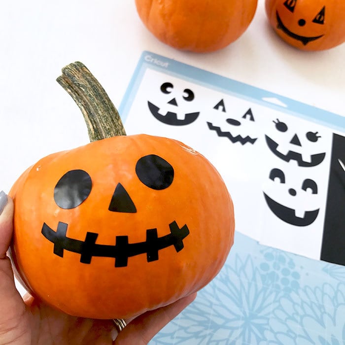 Apply the vinyl cut-outs to the pumpkin