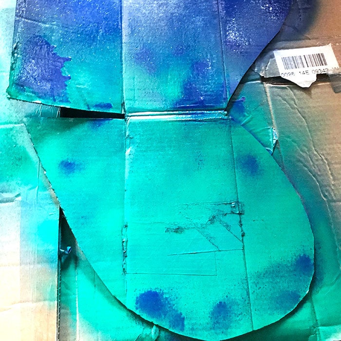 Add green spray paint on top of wet blue paint