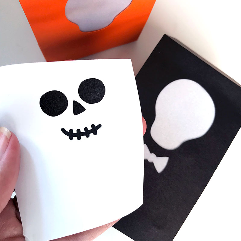 Apply the skull faces to decorate your treat bag