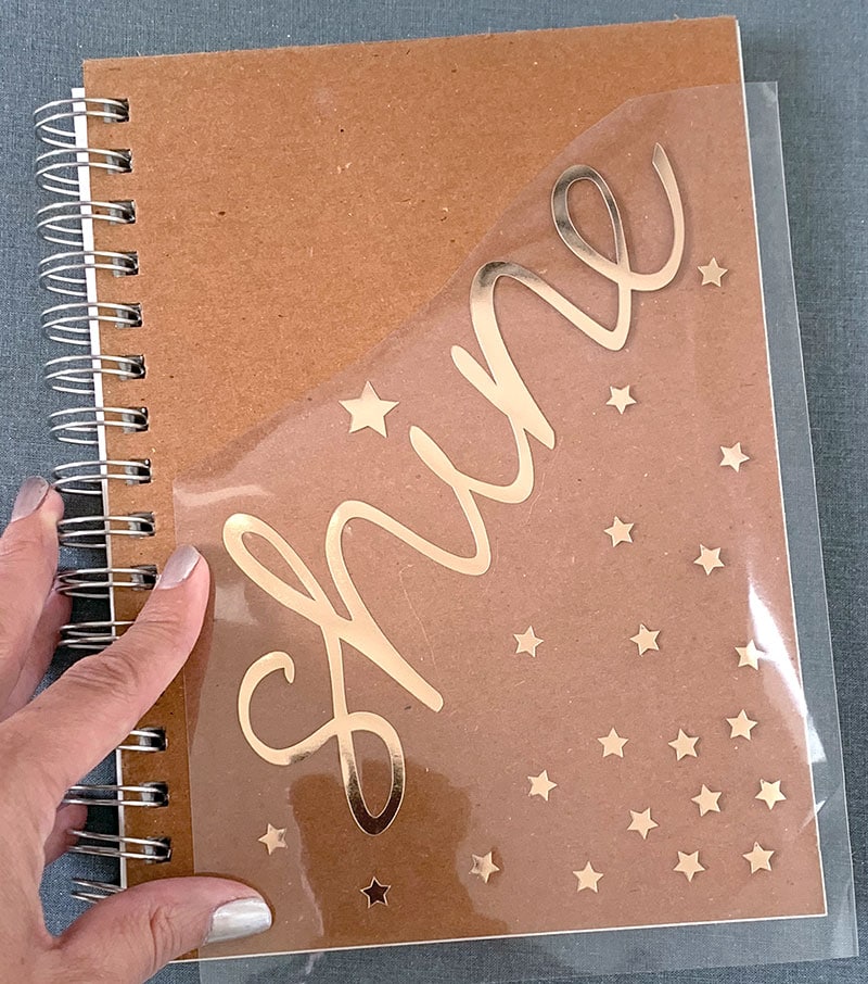 Apply foil iron-on vinyl to your notebook cover to customize it