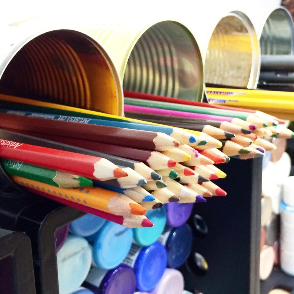 Stack cans with other art supplies for a convenient storage solution