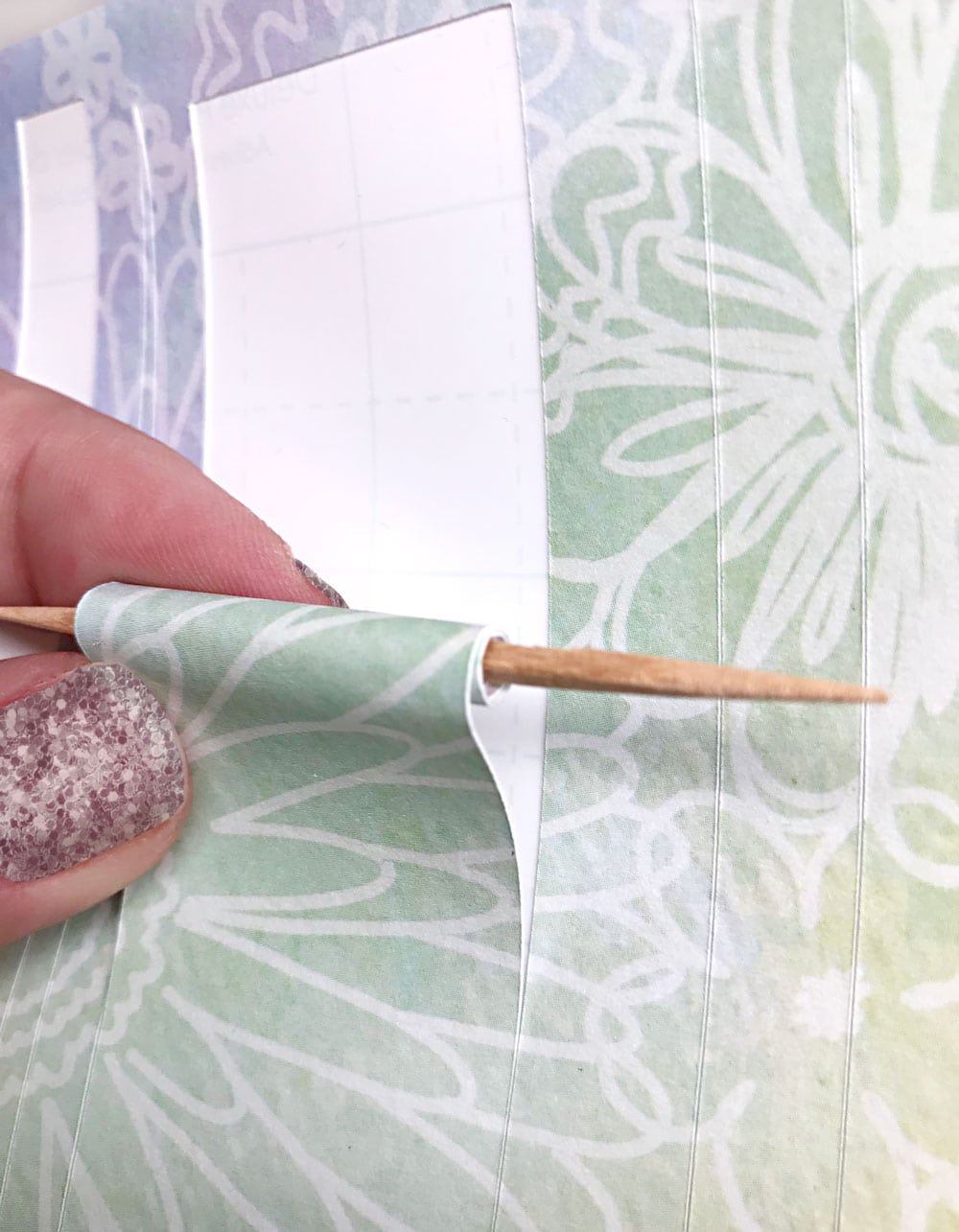 Rolling paper around toothpick to make paper bead.