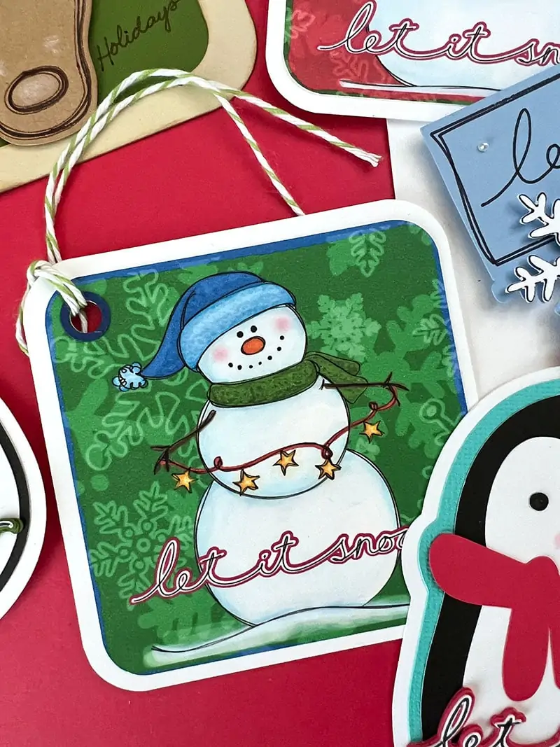 Cute snowman gift tag holding a string of stars